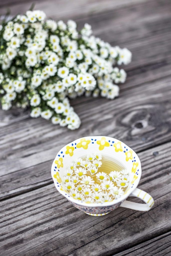 Chamomile tea cup with flowers on table